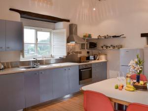 uma cozinha com armários azuis e uma mesa com frutas em Moderno-uk12748 em Menheniot