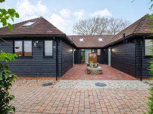 a house with black siding and a brick driveway at Diesels Desirable Den - Uk36786 in Sutton Valence