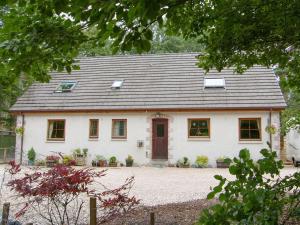 Casa blanca con puerta roja en Woodland Lodge, en Boat of Garten