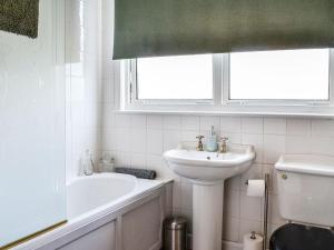 a bathroom with a sink and a bath tub and a window at River View in Dumfries