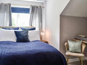sypialnia z niebiesko-białym łóżkiem i oknem w obiekcie River View w mieście Dumfries