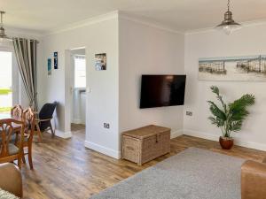 a living room with a flat screen tv on a wall at High Tides in Penclawdd