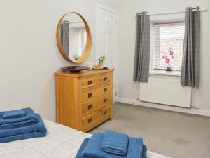 a bedroom with a mirror on top of a dresser at The Cottage in Girvan