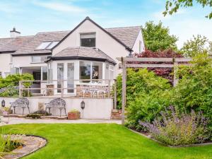 a home with a yard with green grass at Beacon Cottage in Ivegill