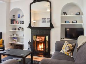 a living room with a fireplace and a mirror at Windy Dales Cottage in Skipton