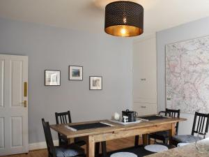a dining room table with chairs and a map on the wall at Windy Dales Cottage in Skipton