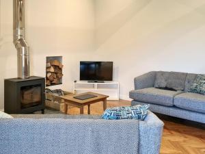 sala de estar con sofá y chimenea en Dowie House Steading, en Cheswick