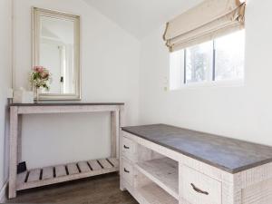 Habitación blanca con mesa y espejo. en The Gatehouse Cottage, en Wells