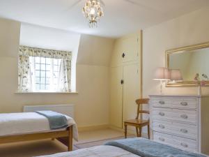 a bedroom with two beds and a dresser and a mirror at Dulcie Cottage in Benson