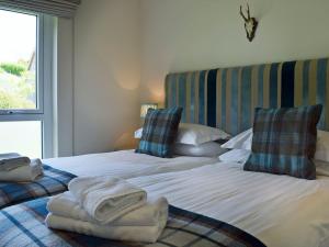 a bedroom with two beds with towels on them at The Bothy in Stron-fearnan