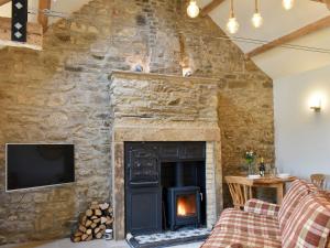 a stone wall with a fireplace in a living room at Harsondale Bothy in Langley