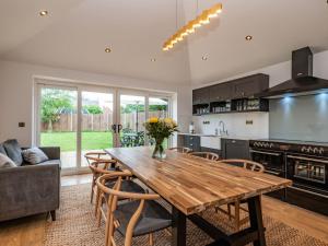 a kitchen and dining room with a wooden table at Clematis Cottage in Thorpe Market