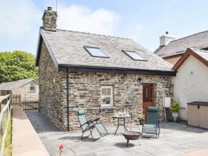 a stone cottage with a patio and chairs at Uk34913 - Bwlchgraig Fach in Nantcwnlle