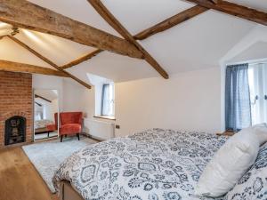 a bedroom with a bed and a fireplace at Clematis Cottage in Thorpe Market