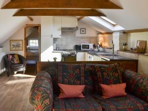 a living room with a couch and a kitchen at Apple Loft in Hotham