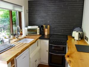a kitchen with a sink and a black brick wall at Uk34351 - Squirrel Cottage in Betws-y-coed