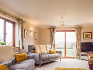 a living room with a couch and a tv at The Larches in Hopton Cangeford