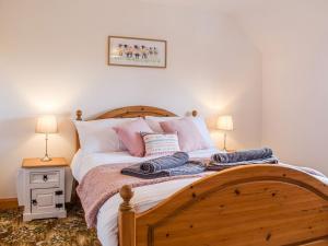 a bedroom with a wooden bed with two lamps at The Larches in Hopton Cangeford