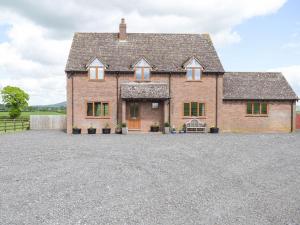 a large brick house with a gravel driveway at The Larches in Hopton Cangeford