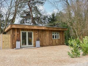 ein kleiner Holzschuppen mit einem großen Fenster in der Unterkunft The Retreat in Saint Leonards