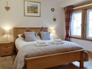 a bedroom with a bed with two towels on it at Baldowrie Farm Cottage in Ardler