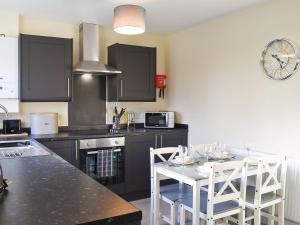 - une cuisine avec une table et deux chaises blanches dans l'établissement One Dorchester Drive - Uk32037, à Inglewhite