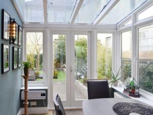 un aranceto con giardino d'inverno dotato di tavolo e finestre di The Apartment a Brecon