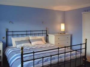 um quarto azul com uma cama e uma cómoda em Stronafian House em Feorlean