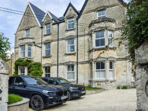 deux voitures garées devant un bâtiment dans l'établissement Flat 3 Avon Villa, à Bradford-on-Avon