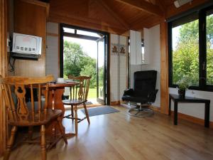 uma sala de estar com uma mesa e cadeiras e uma secretária em Red Lodge - Uk10988 em Llandogo