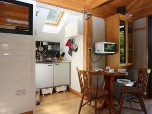 a small kitchen with a table and a microwave at Red Lodge - Uk10988 in Llandogo