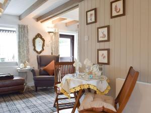 a living room with a table and a chair at Horseshoe Cottage in Fife