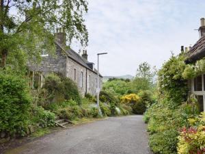 una calle vacía en un pueblo con casas en Horseshoe Cottage, en Fife