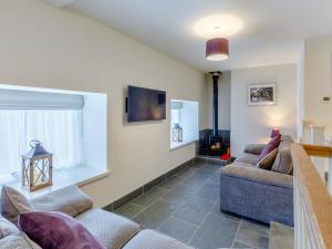 a living room with two couches and a tv at Willow Cottage At Naze Farm-uk32760 in Chinley