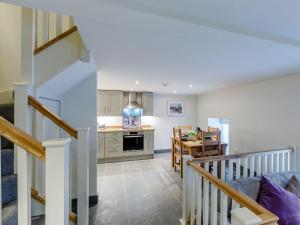 a kitchen and a living room with a staircase at Willow Cottage At Naze Farm-uk32760 in Chinley