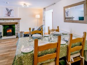 comedor con mesa y chimenea en Woodlands Clough - Uk32387, en Dunford Bridge