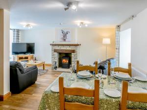 a living room with a table and a fireplace at Woodlands Clough - Uk32387 in Dunford Bridge