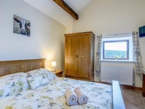 1 dormitorio con 1 cama con 2 toallas en Woodlands Clough - Uk32387, en Dunford Bridge
