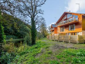 ein Haus auf einer unbefestigten Straße neben einem Baum in der Unterkunft Waterside Lodge Three - Uk33350 in Southowram