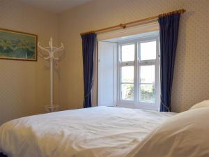 a bedroom with a large bed and a window at Collingwood in Marloes