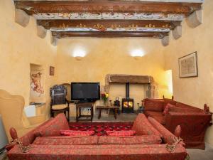 a living room with a red couch and a tv at Braidwood Castle - Uk10672 in Braidwood