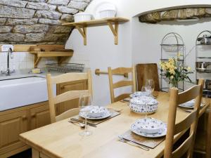 uma cozinha com uma mesa de madeira com pratos e copos em Braidwood Castle - Uk10672 em Braidwood