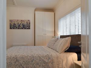 a bedroom with a bed and a window at Kingsley Cottage in Darenth