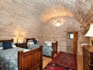 a bedroom with two beds and a stone wall at Braidwood Castle - Uk10672 in Braidwood