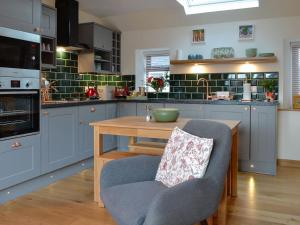 a kitchen with blue cabinets and a wooden table at Howe Cottage in Laurencekirk