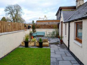 a small patio with a blue bench in a backyard at Howe Cottage in Laurencekirk