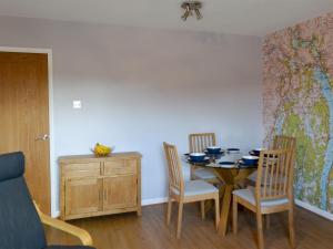 a dining room with a table and chairs and a map at Lake View in Bowness-on-Windermere