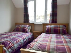 a bedroom with two beds and a window at Lake View in Bowness-on-Windermere