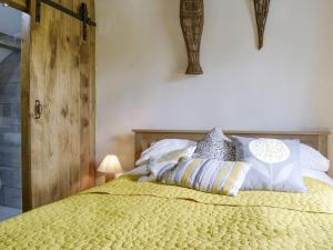 a bedroom with a yellow bed with pillows on it at Springlea Cottage in Dean