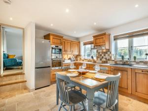 a kitchen with wooden cabinets and a table and chairs at River View in Trimingham